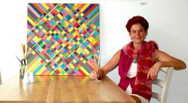 il-collezionista-2014 women sitting with a glass of wine beside a geometric paninting
